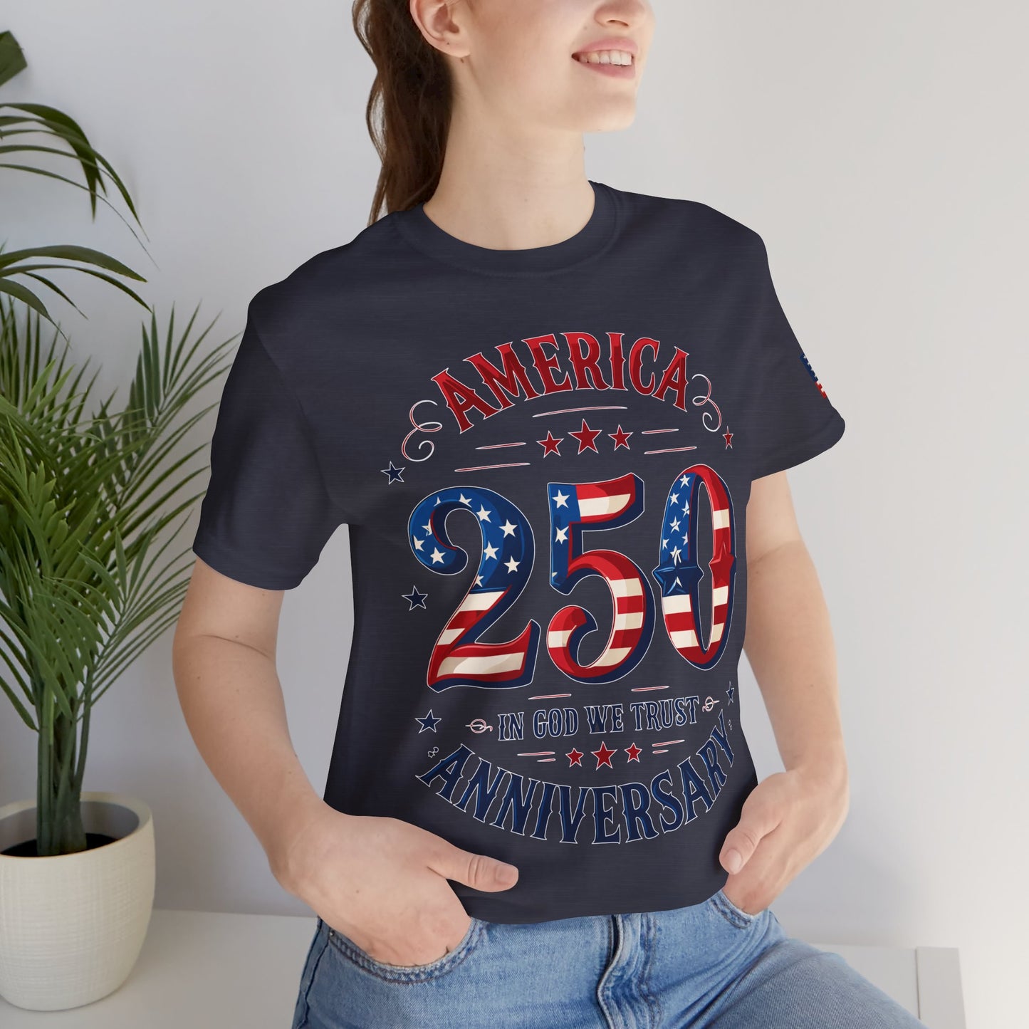 Person wearing a navy blue t-shirt with 'America 250 Anniversary' design, standing indoors.
