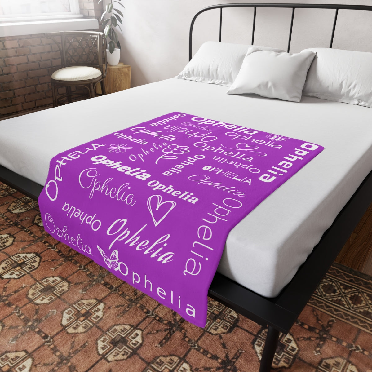Purple blanket with custom name pattern on a bed in a bedroom.