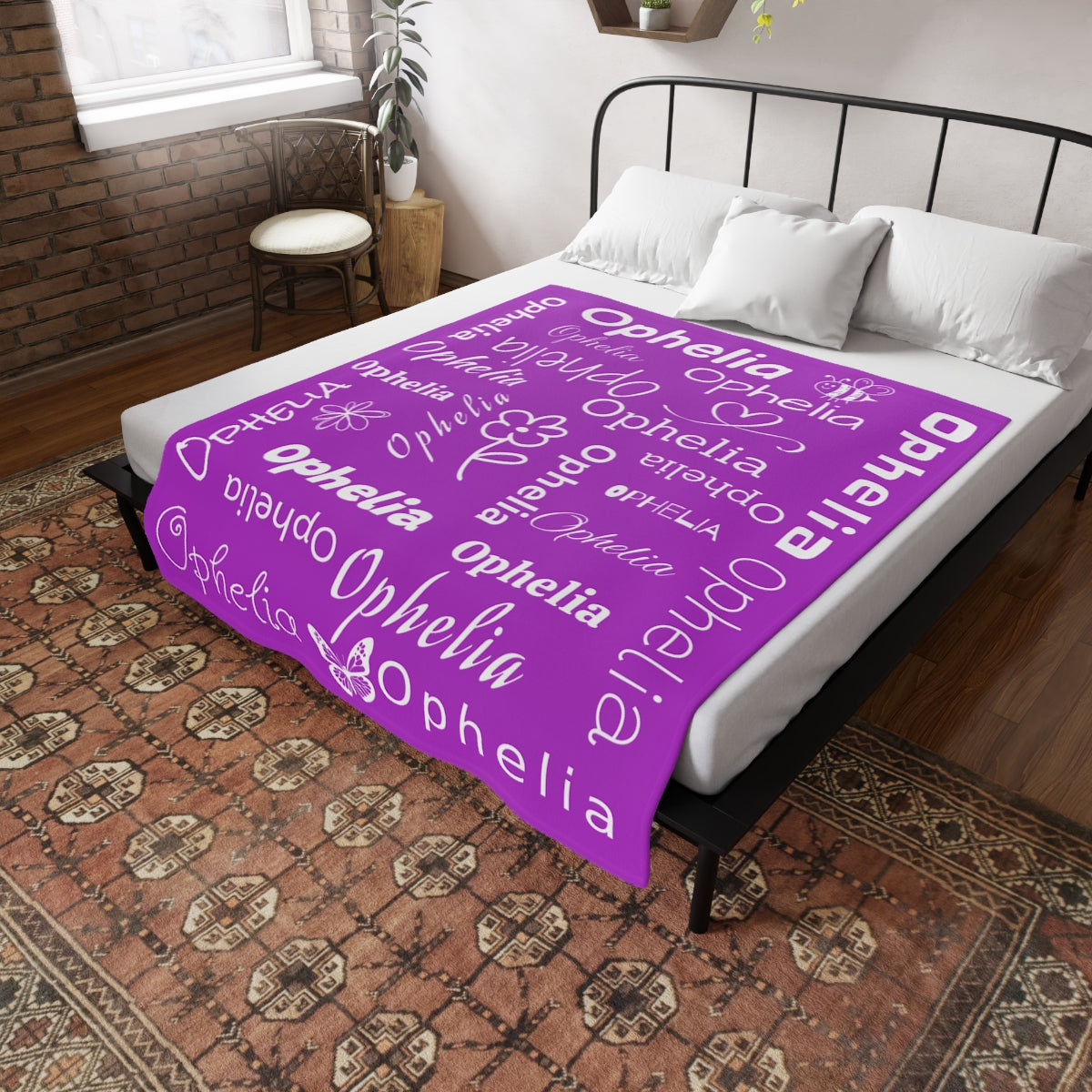 Purple blanket with custom name text draped over a bed in a bedroom.