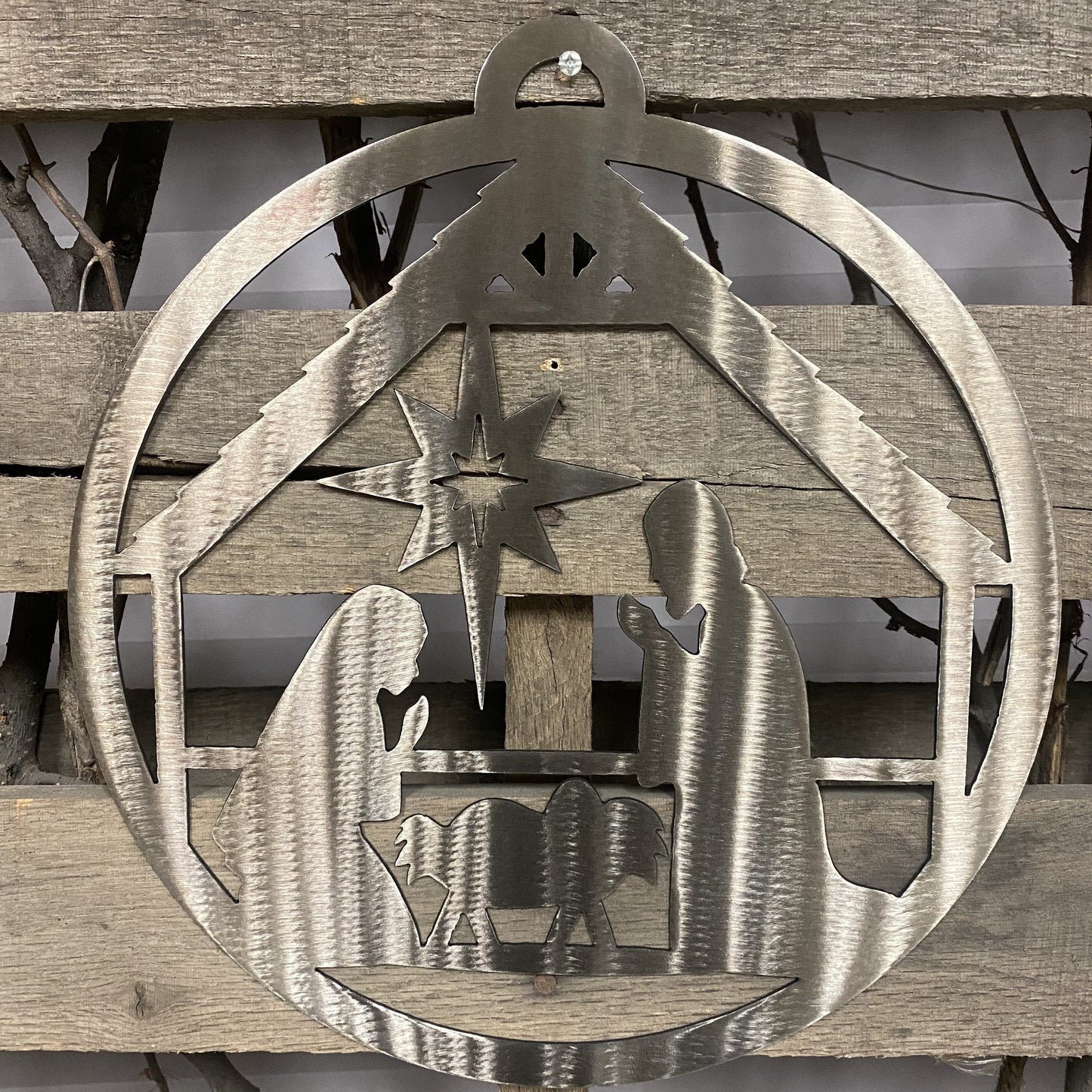 Decorative metal nativity scene on a wooden background