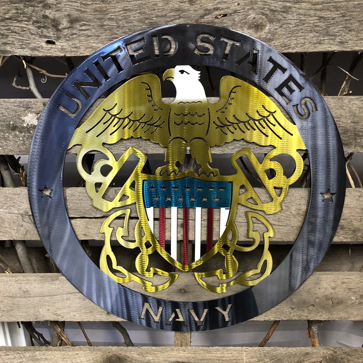Metal plaque with 'United States Navy' emblem on a wooden background