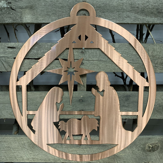 Decorative metal nativity scene cutout on a wooden background