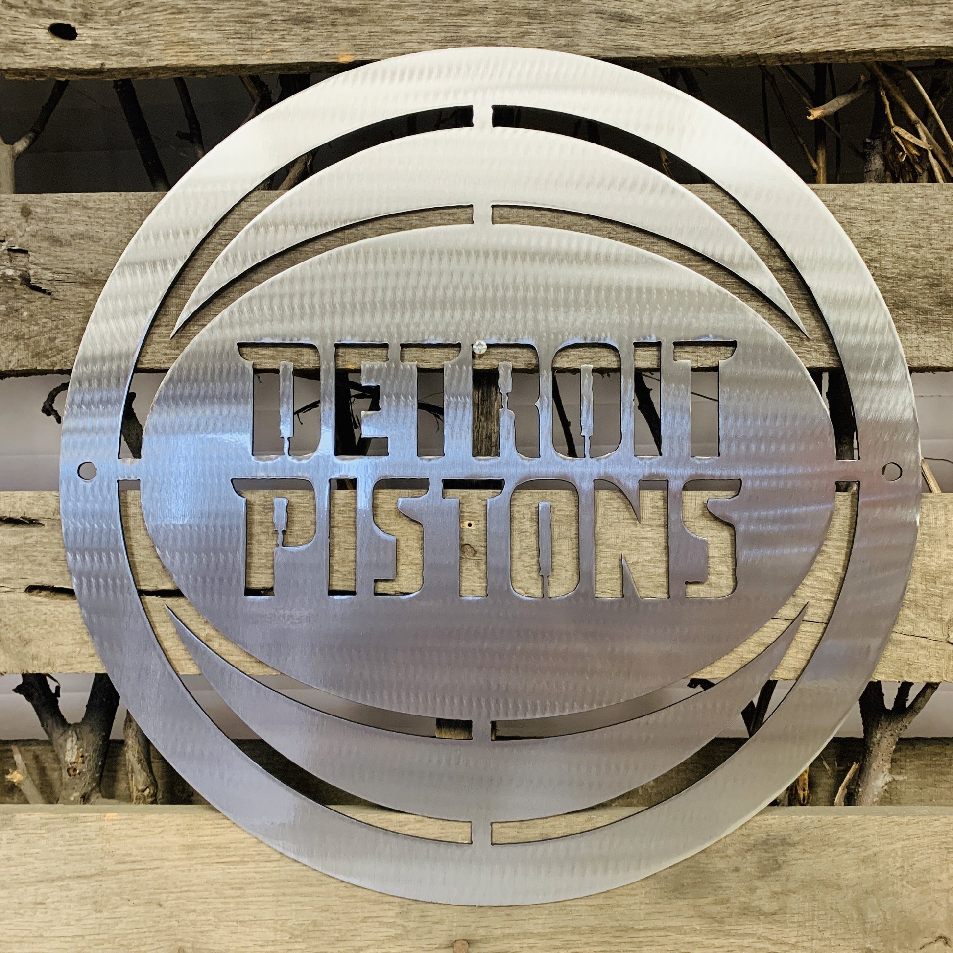 Silver Metallic 'Detroit Pistons' logo on a wooden background