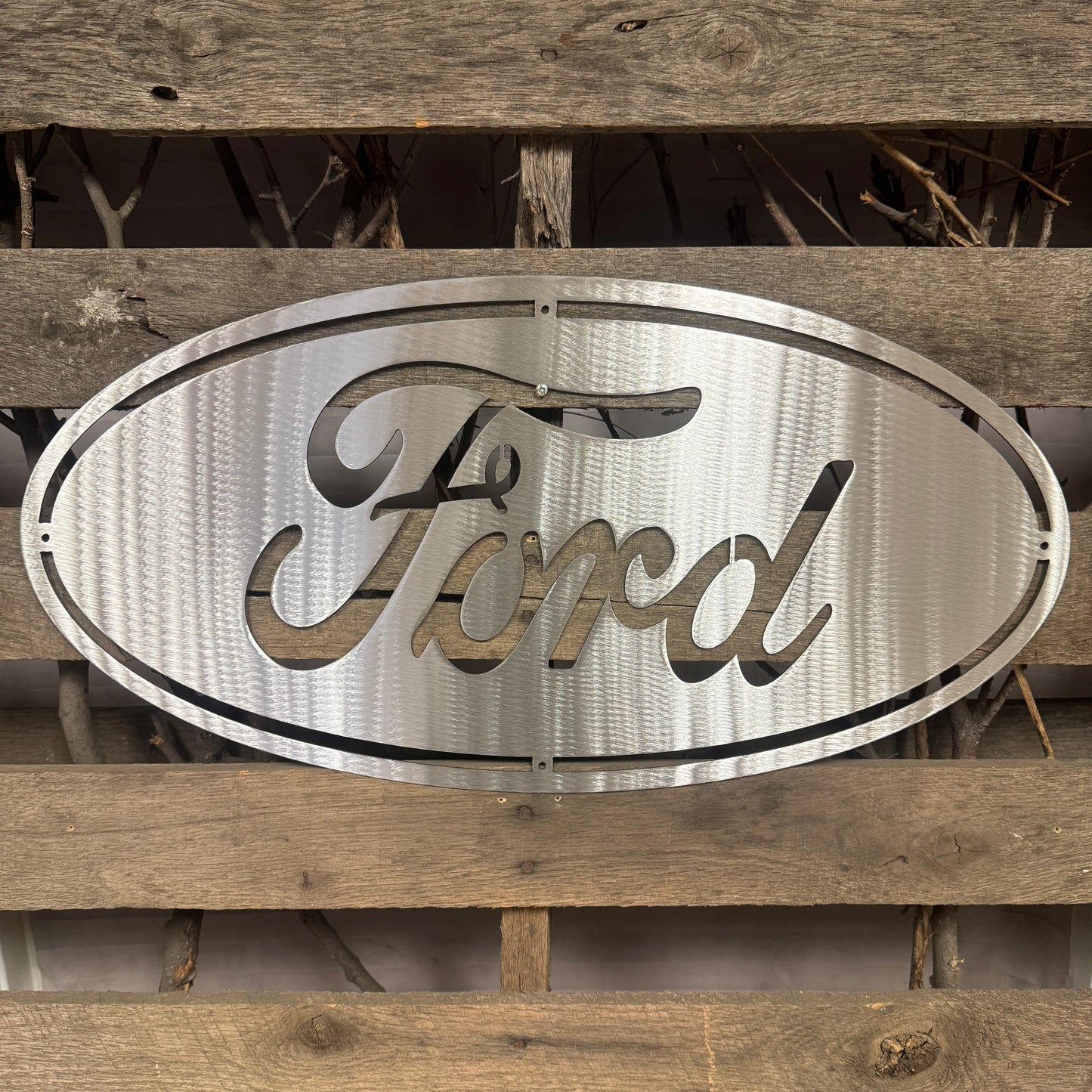 Metallic Ford logo on a wooden background