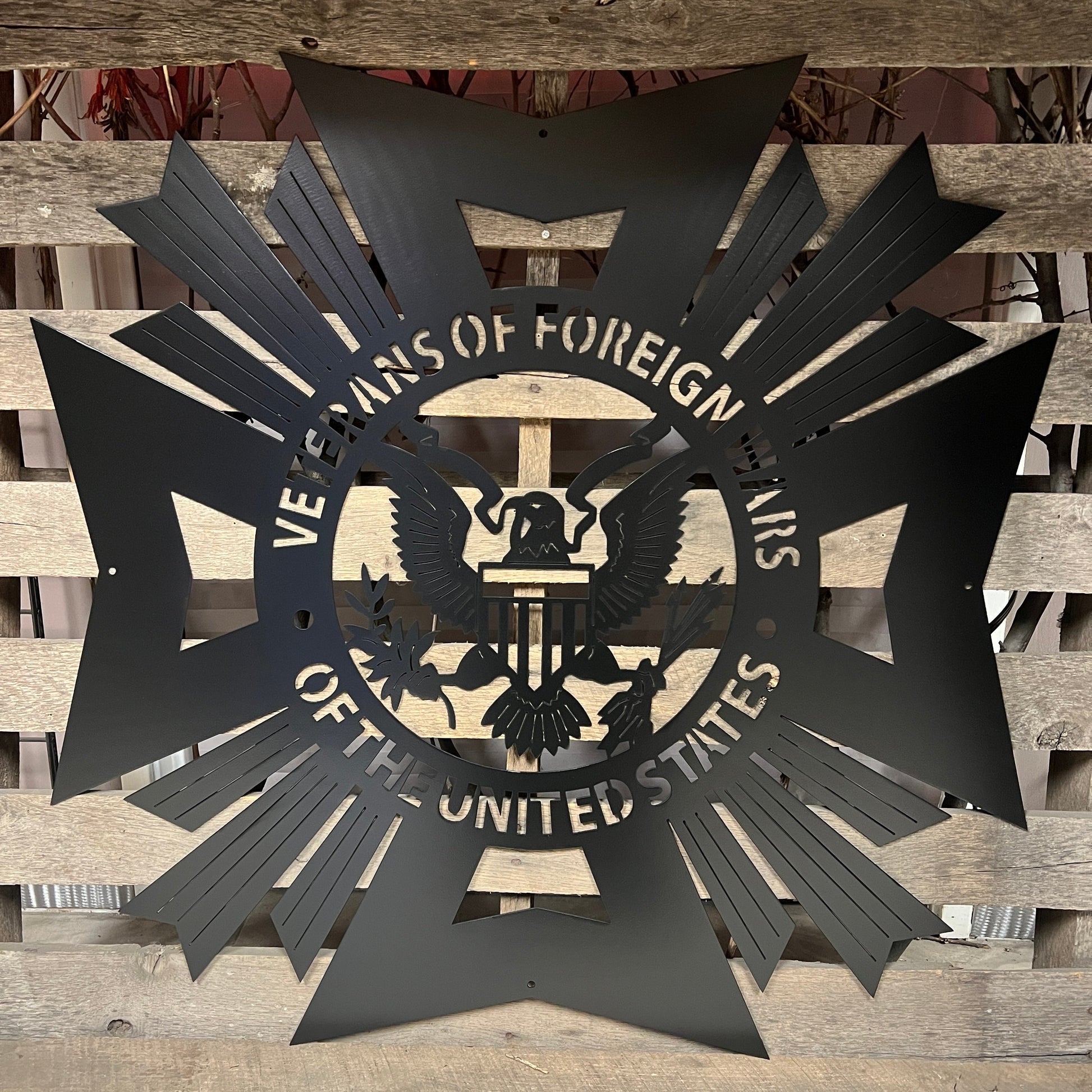 Black Decorative metal sign with 'Veterans of Foreign Wars of the United States' emblem on a wooden background