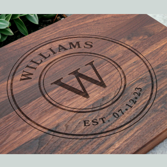 Wooden cutting board with engraved 'WILLIAMS' and 'W' design.