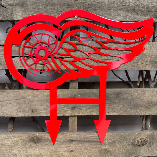 Red metal winged logo on a wooden background