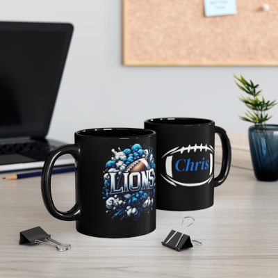 Two black mugs with sports-themed designs on a desk with office supplies.