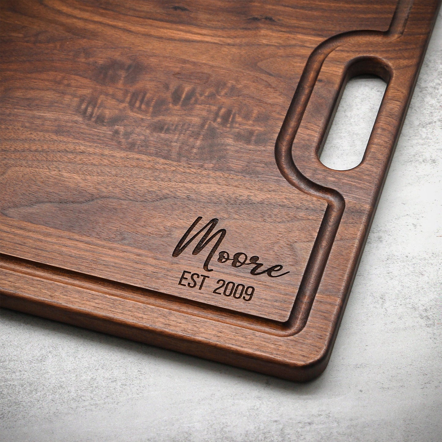 Wooden cutting board with engraved text on a gray surface