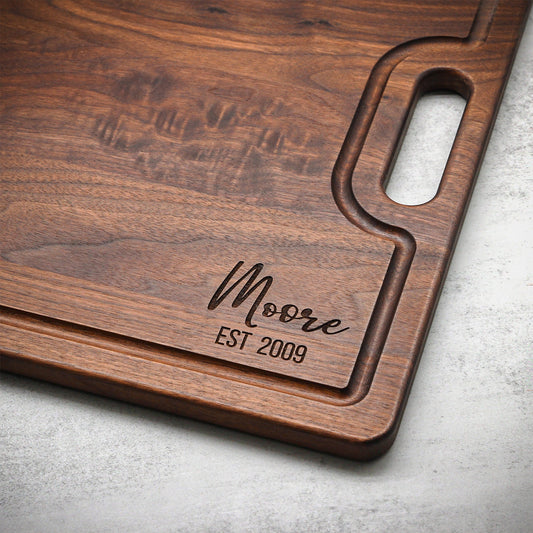 Wooden cutting board with engraved text on a gray surface