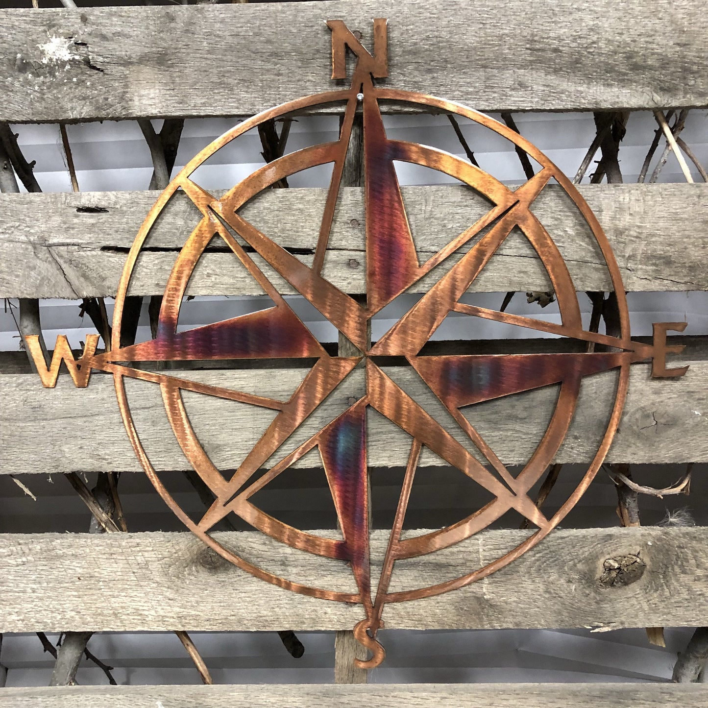 Burnished-colored metal compass on a wooden background