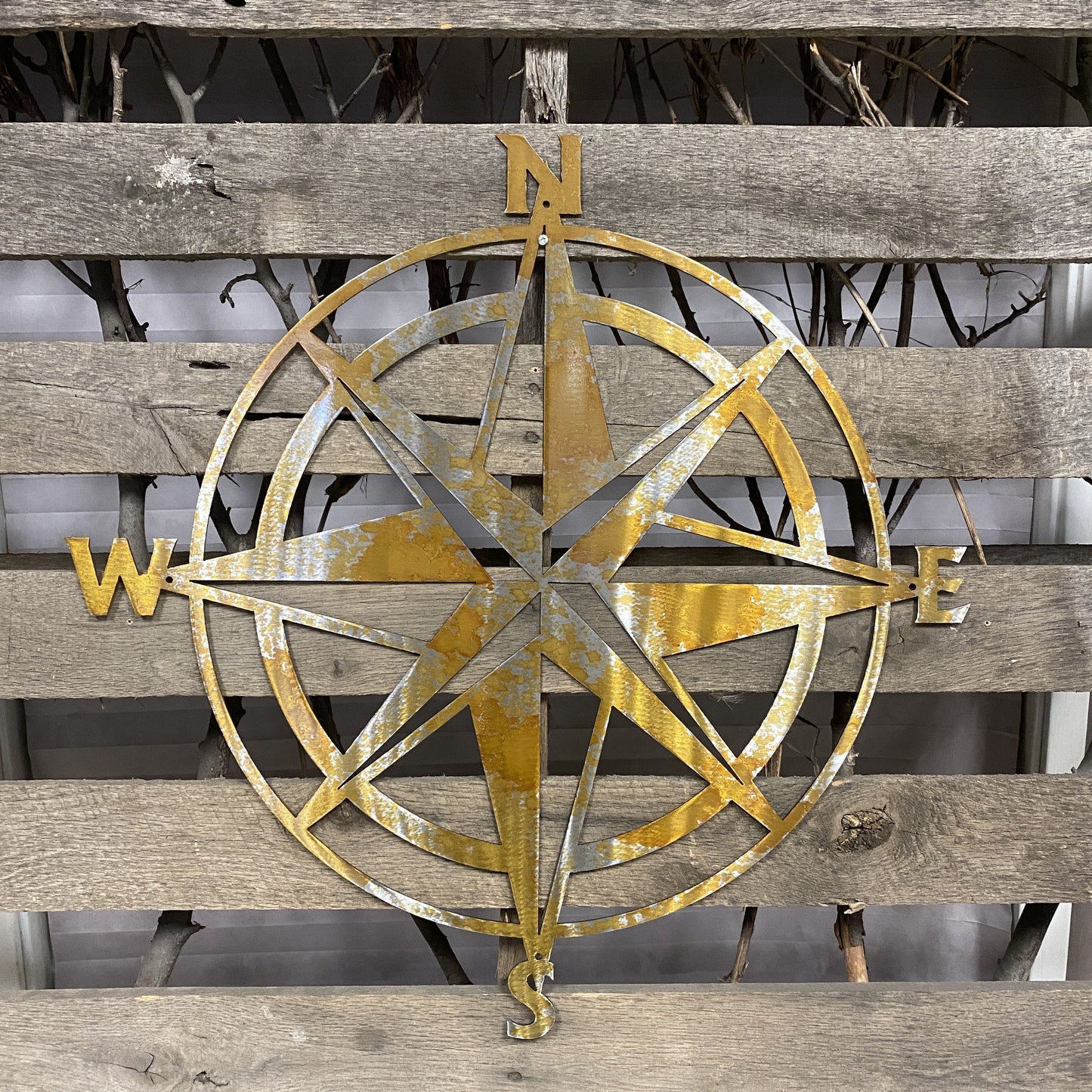 Decorative metal compass rose on a wooden background