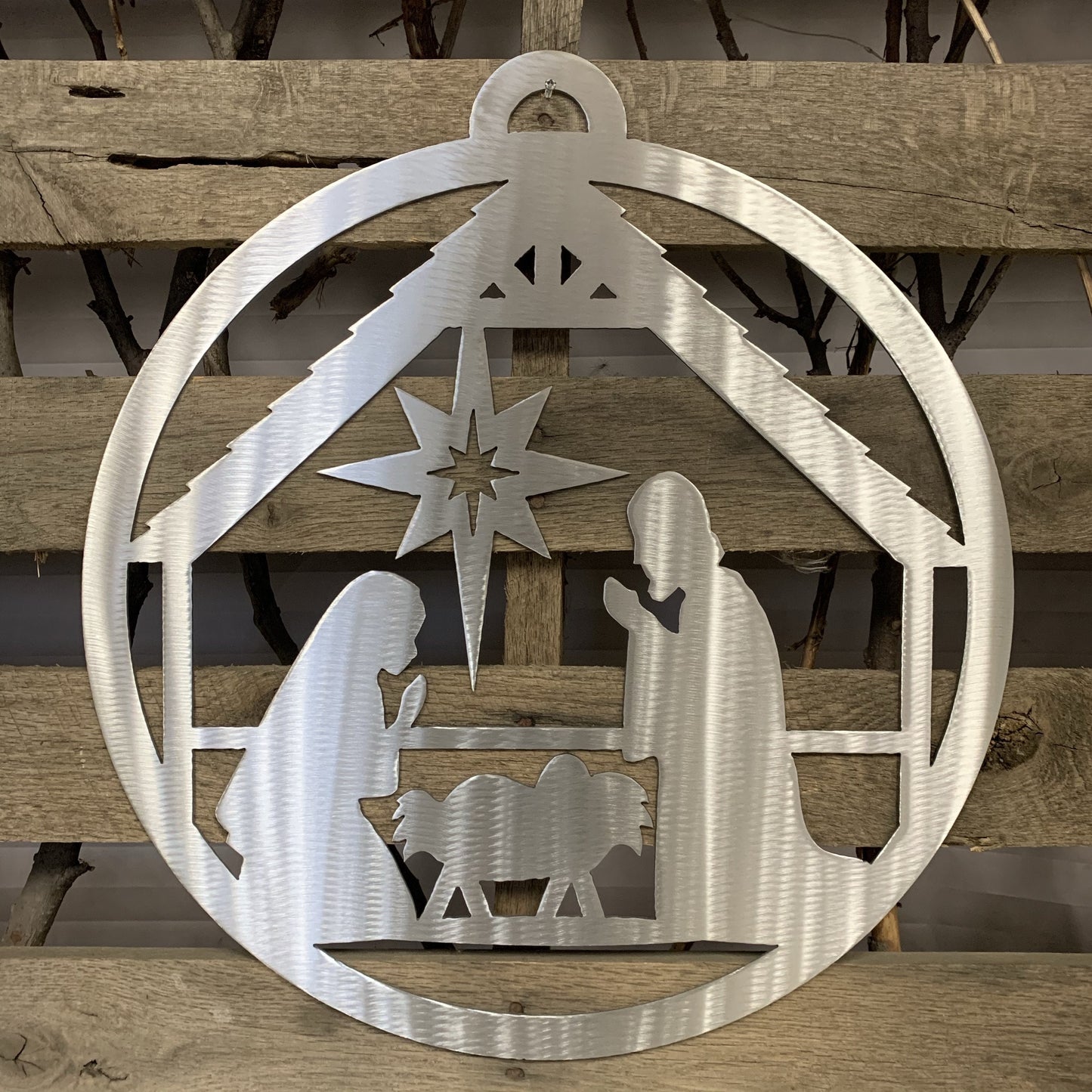 Metal nativity scene cutout with star on a wooden background