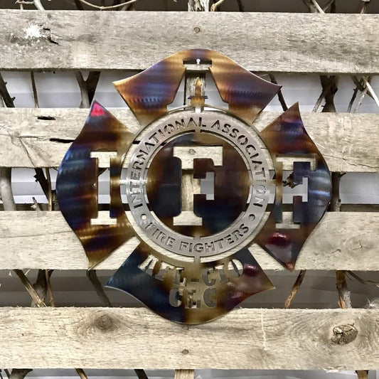 Burnished Decorative metal sign with 'International Association of Fire Fighters' logo on a wooden background