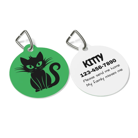 Two round pet tags, one green with a black cat illustration and the other white with text, on a white background.