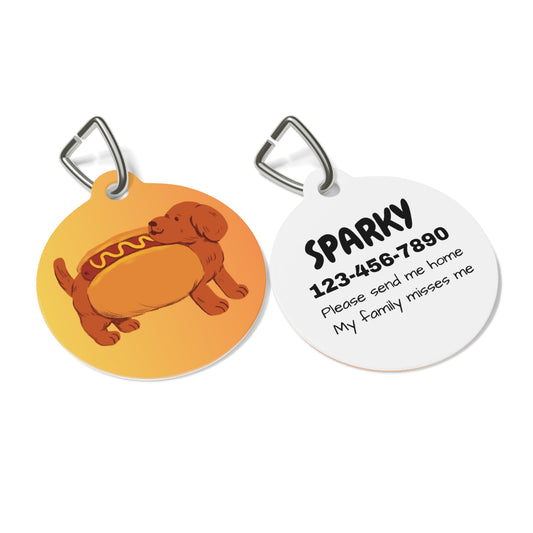 Two dog tags; one orange with a dog illustration, the other white with text and a phone number.