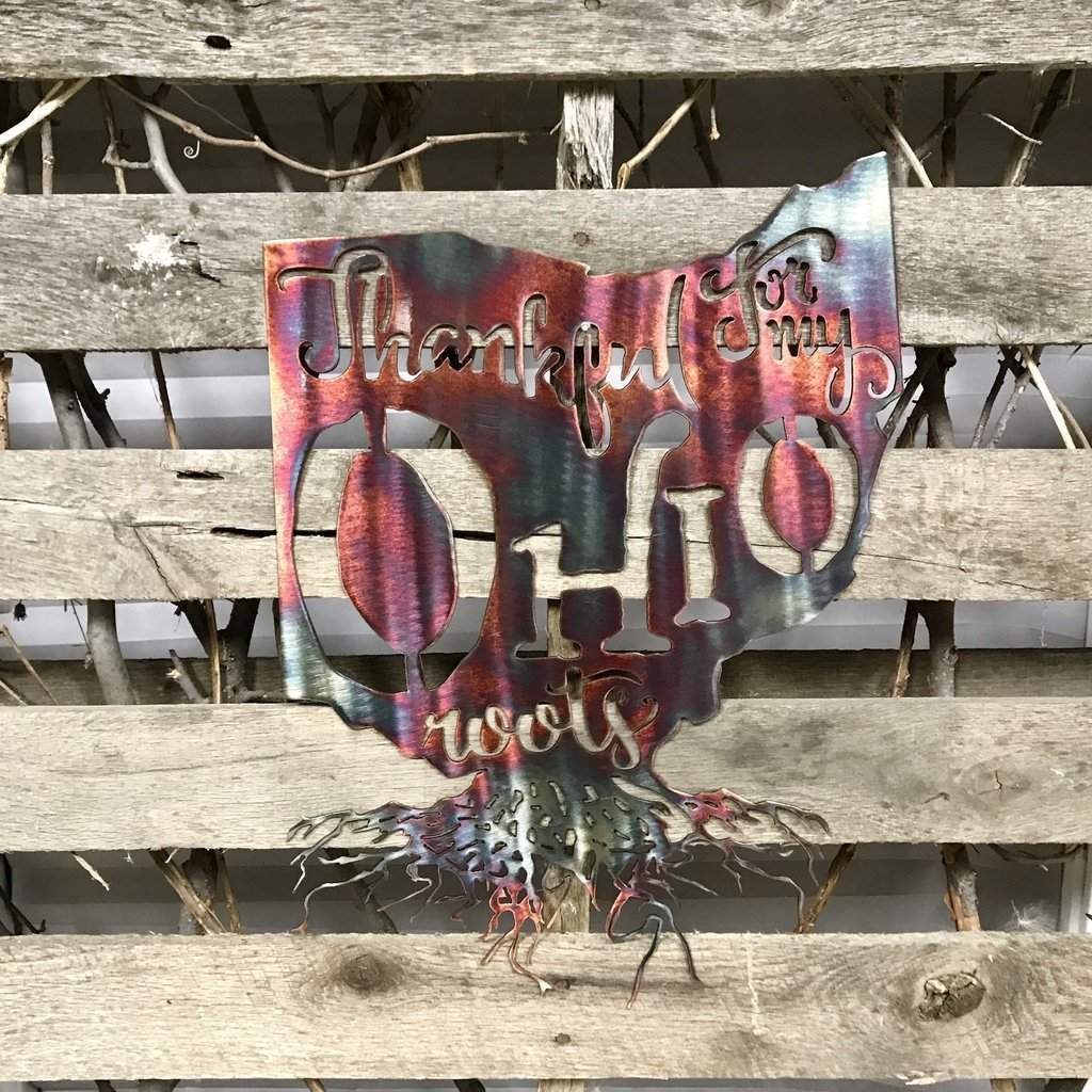 Metallic Ohio-shaped sign with 'Thankful for my Ohio roots' text on a wooden background