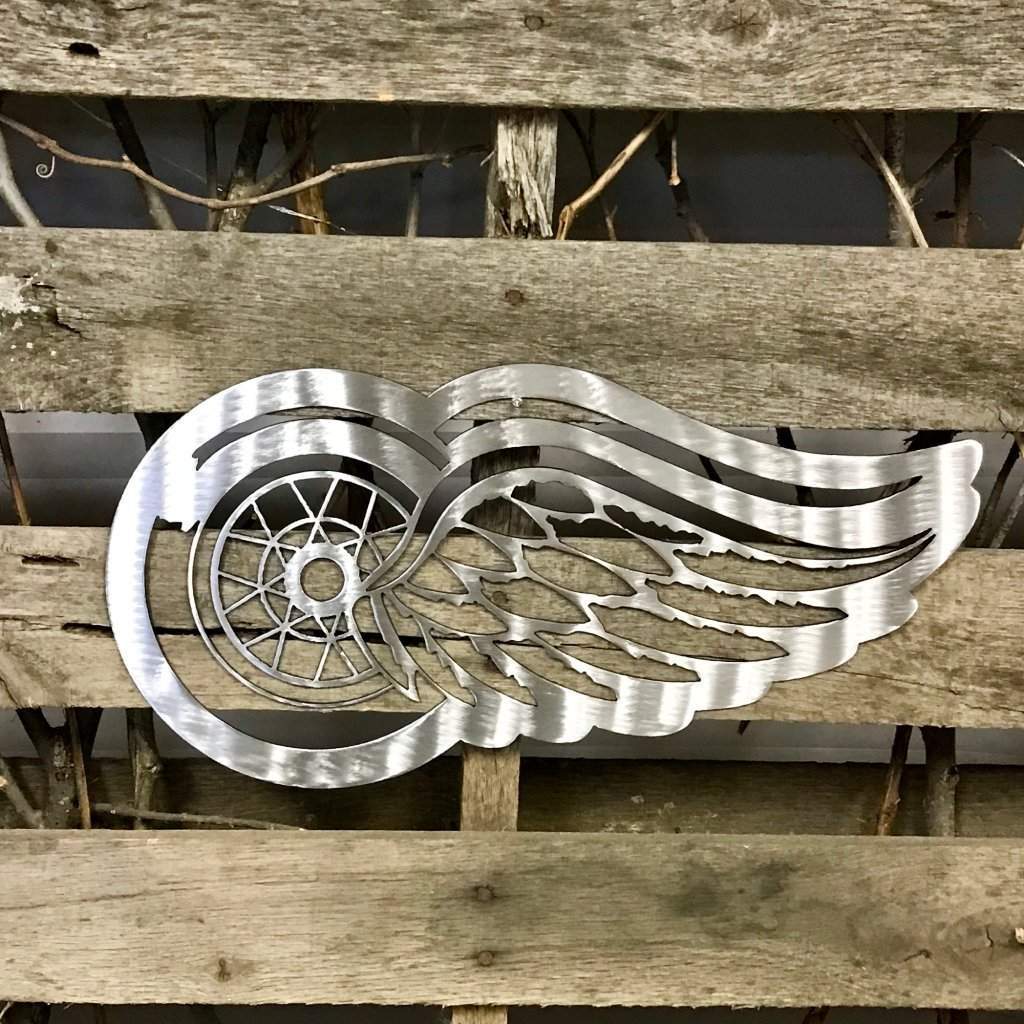 Silver Detroit Redwinged metal winged symbol on a wooden background